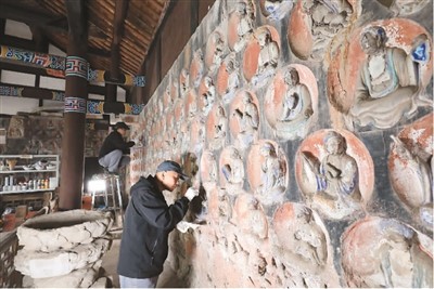 　2023年3月31日，大足石刻小佛灣修復現場，修復人員正在對石窟造像進行清理。小佛灣石窟保護修復工程于2019年6月啟動，目前已完成整個工程量的六成。  　　黃 舒攝（人民圖片）