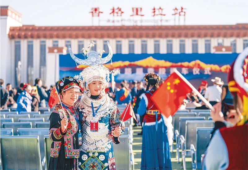 2023年11月26日，麗江至香格里拉鐵路開通運營。麗香鐵路起自云南省麗江市玉龍納西族自治縣麗江站，接入云南省迪慶藏族自治州香格里拉市香格里拉站，穿越青藏高原橫斷山區腹地，途經多個民族聚集地。圖為麗香鐵路開通當日，參加通車儀式的少數民族代表拍照留念。 新華社記者 陳欣波/攝