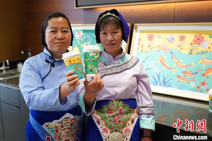 圖為農民畫家展示她們被印在星巴克咖啡紙杯上的畫作。中新網記者劉冉陽 攝