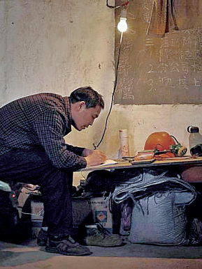 礦工陳年喜在燈下寫作。資料圖片