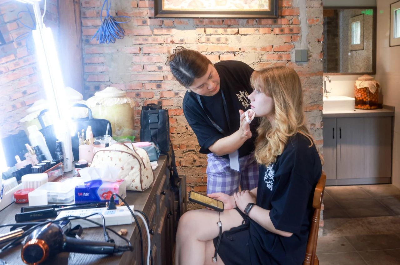 2025年6月30日，百集微短劇《鐘鼓樓前》在北京鼓樓前開機。圖為俄羅斯籍女演員瑪利亞在開拍前化妝。 中新社記者 賈天勇 攝