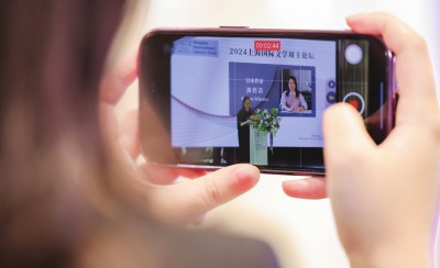在2024上海國際文學周主論壇的會場，一位觀眾在用手機錄制日本推理小說家湊佳苗的發言。上海國際文學周供圖